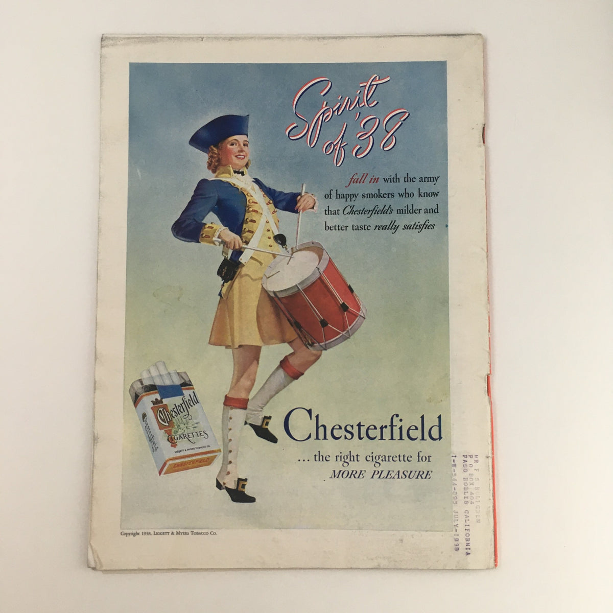 Back cover of a vintage magazine from June 27, 1938, featuring an advertisement for Chesterfield cigarettes with a smiling woman in a colonial outfit playing a drum, promoting the brand's taste.