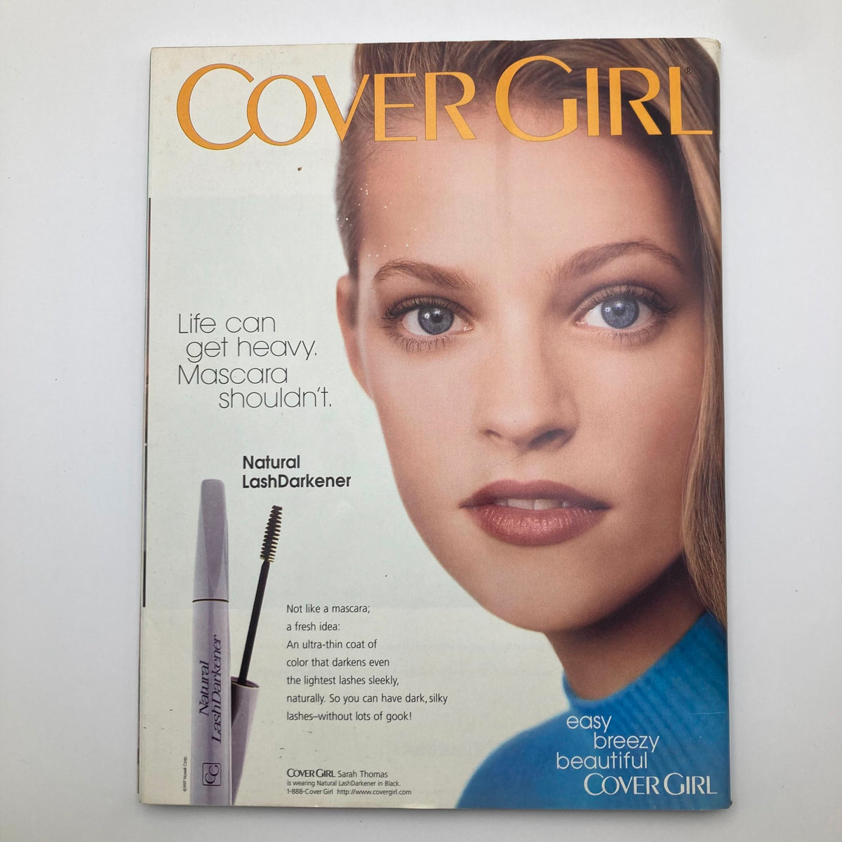 Vintage Cover Girl advertisement highlighting Natural LashDarkener, promoting light and easy mascara application. Features an attractive model with bright eyes and a fresh look, set in an appealing layout.