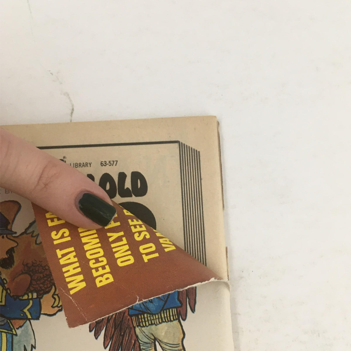 Detailed view of the edge of Mad Magazine June 1971 No. 143, featuring a finger pointing at a page corner, illustrating the magazine's vintage feel.