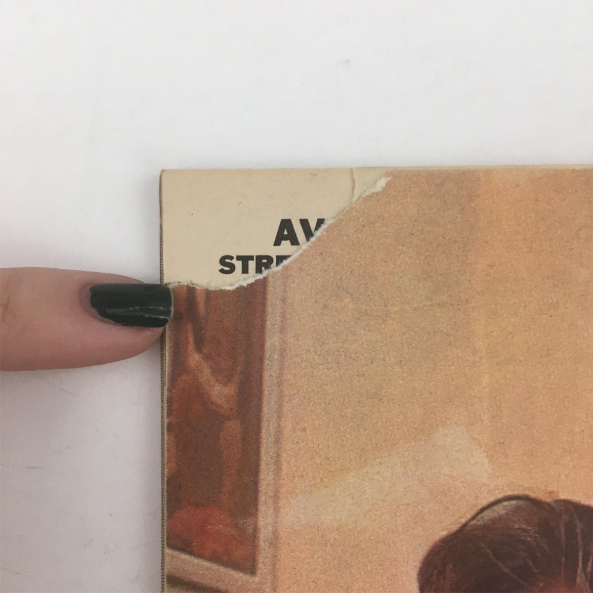 Close-up image of the top left corner of the back cover of Mad Magazine December 1962 No. 75 Cutting Classes Issue, showing a damaged edge with the words 'AV STR'. The image highlights the wear of this vintage magazine.