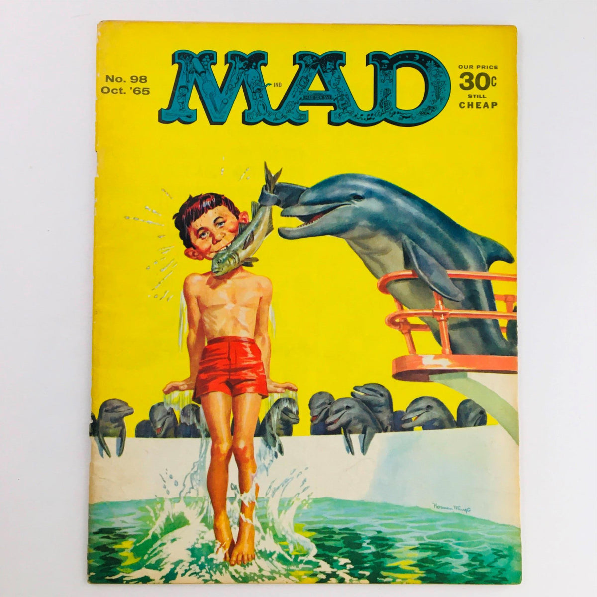 Cover of Mad Magazine October 1965 No. 98 depicting a humorous illustration of a boy in swimming trunks having a dolphin playfully splashing water and holding a fish, capturing the essence of 1960s satire and humor.