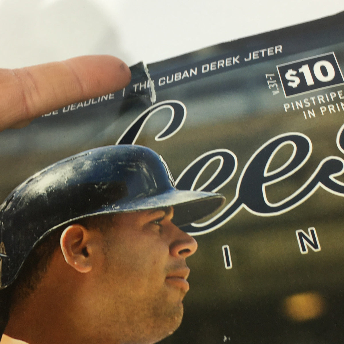 Detail shot of Yankees Magazine: September 2016 Volume #37-7 - Gary Sanchez Game Changer, showing a close-up of the magazine's top edge with a hand holding it and the title partly visible.