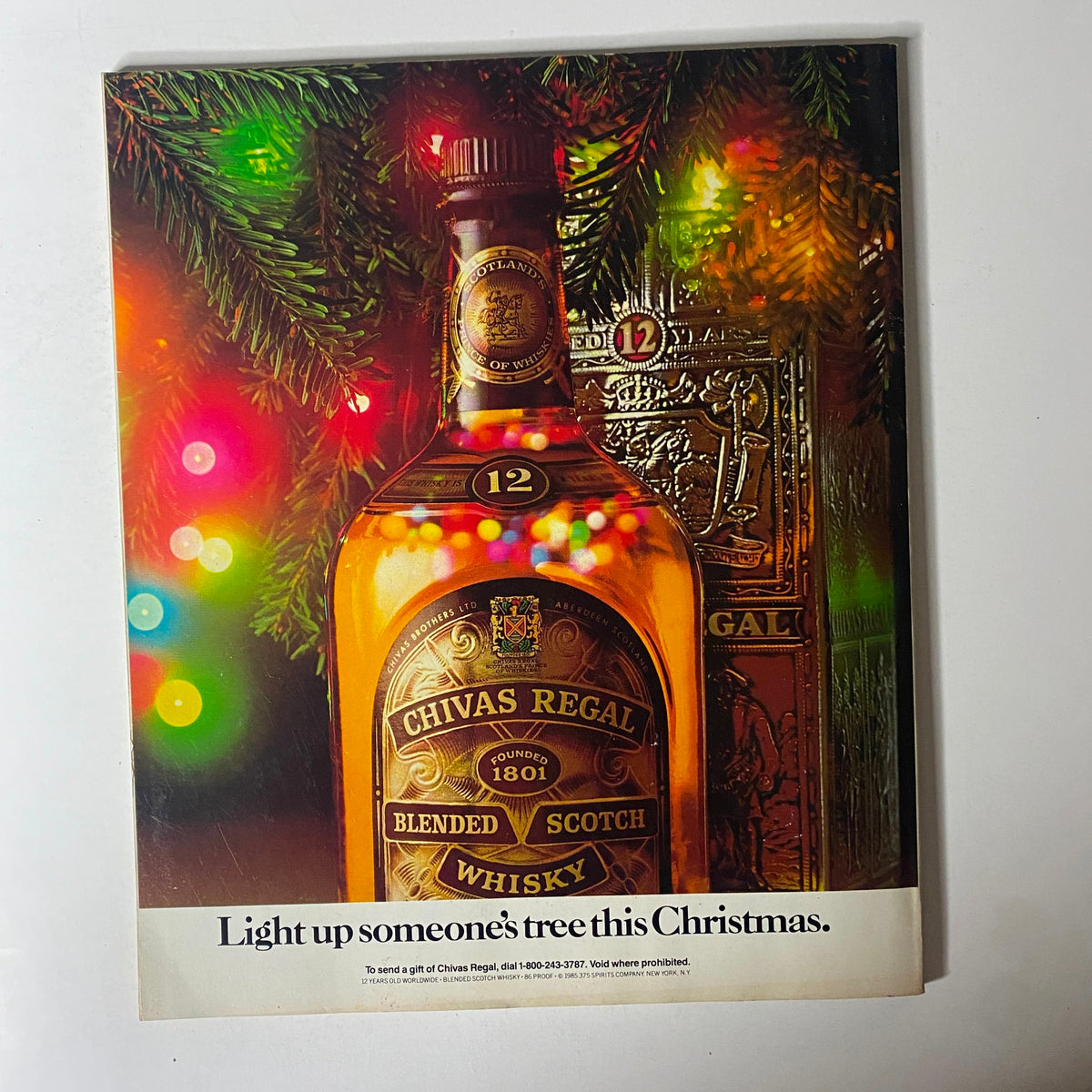 Ad page from Fortune Magazine, December 23, 1985, featuring a Chivas Regal whisky bottle surrounded by festive decorations.