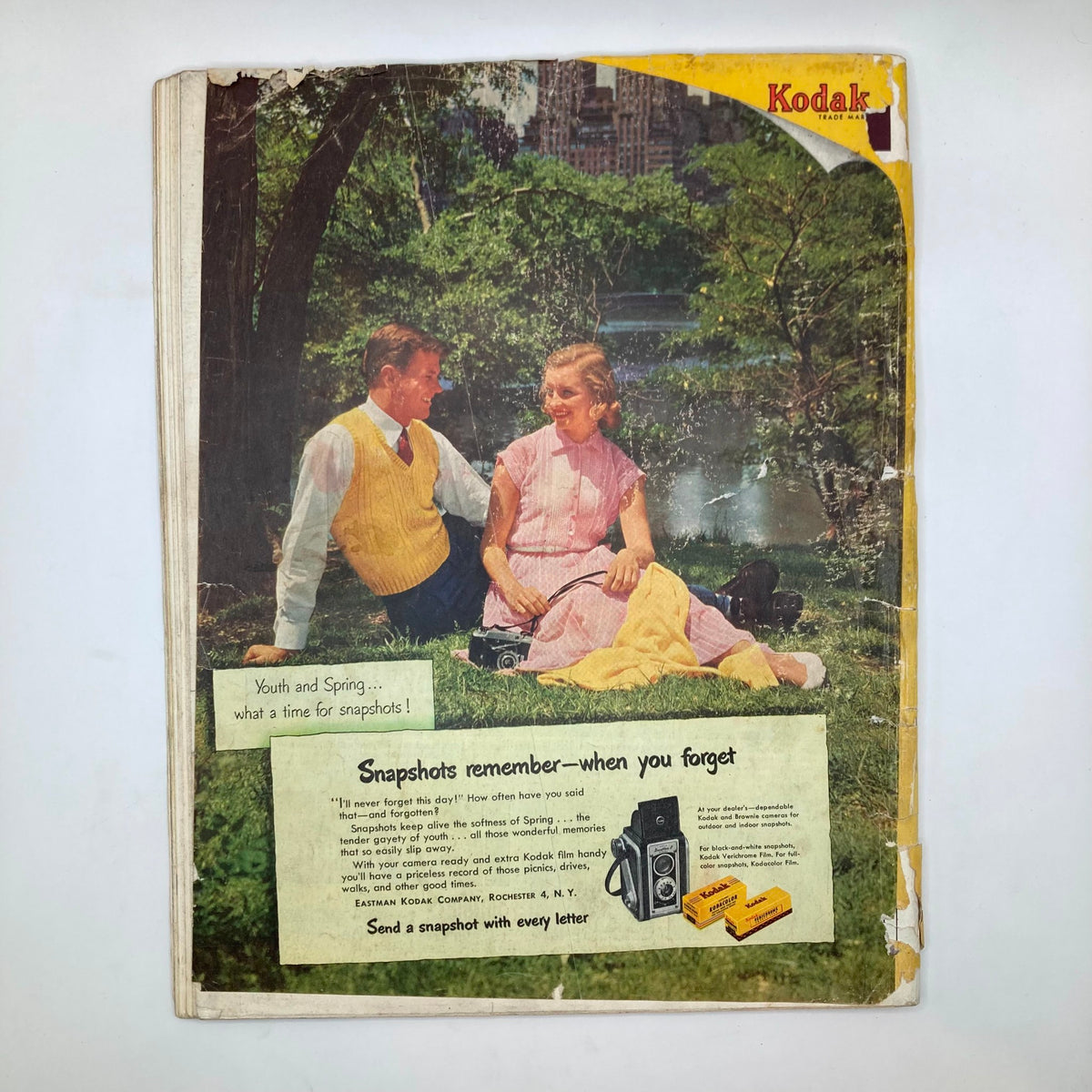 Cover of Saturday Evening Post Magazine from April 12, 1952 featuring a couple enjoying a picnic in a park, with the caption highlighting Kodak's camera advertisements. Perfect for collectors of vintage magazines and mid-century Americana.