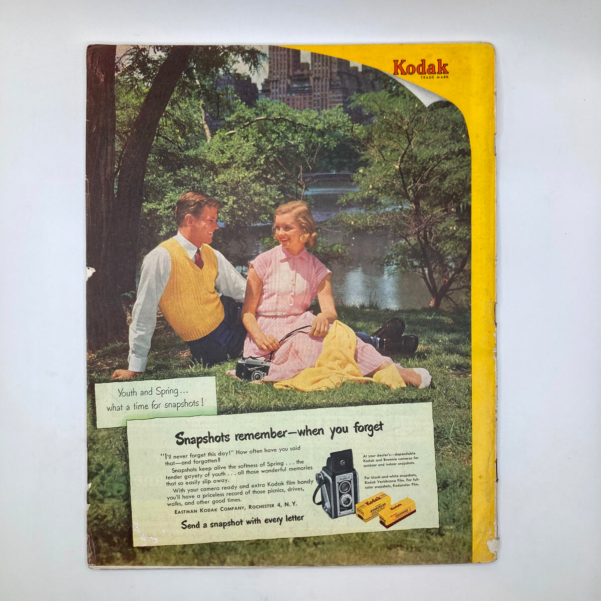 Back cover of the Saturday Evening Post Magazine from April 12, 1952, displaying a nostalgic Kodak advertisement featuring a couple in a park, promoting snapshot photography and spring themes.
