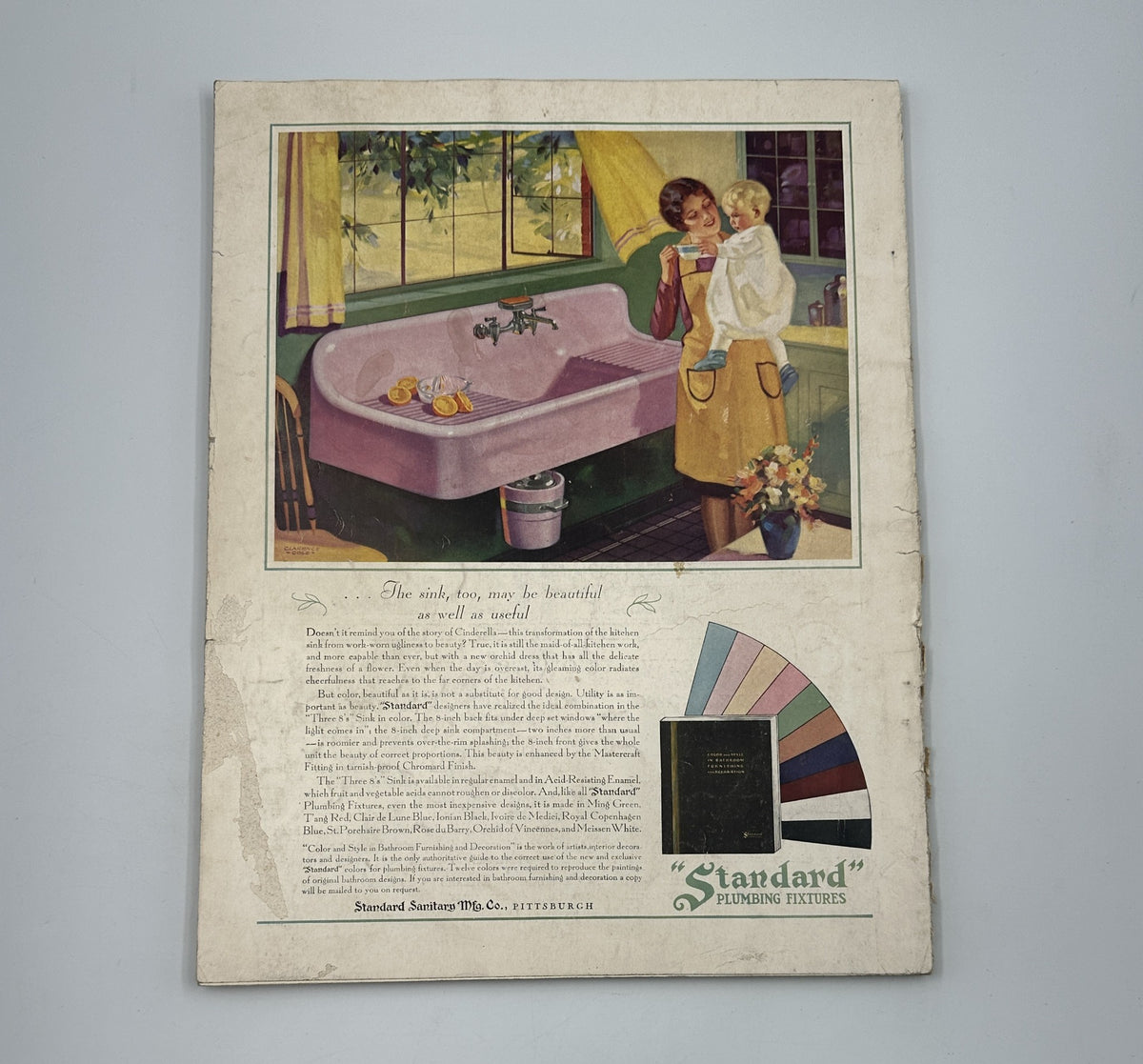 Vintage advertisement illustration from House Beautiful Magazine August 1929, featuring a woman and child by a stylish purple couch with floral decor and color palette samples.