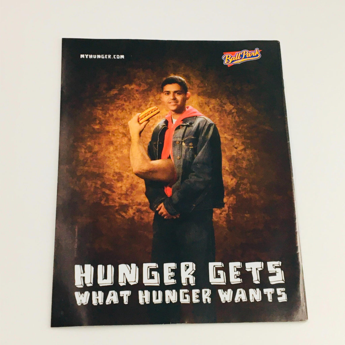 Promotional image for Ball Park hot dogs featuring a young man with an arm reaching for a hot dog, emphasizing the tagline 'Hunger Gets What Hunger Wants'.