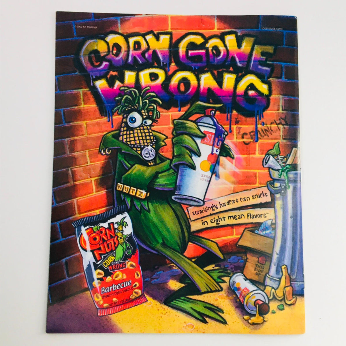 Mad Magazine promotional image for 'Corn Gone Wrong', showcasing a quirky green character in an urban setting, advertising snacks in eight flavors, connected to the humorous theme of Mad Magazine.