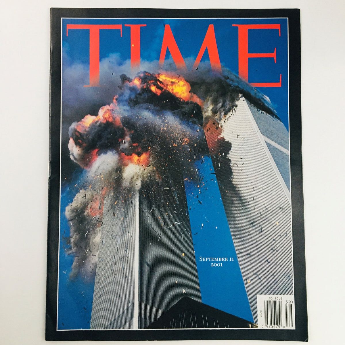 Time Magazine September 11 2001 Day of Infamy featuring a dramatic cover image of the Twin Towers engulfed in flames and smoke.