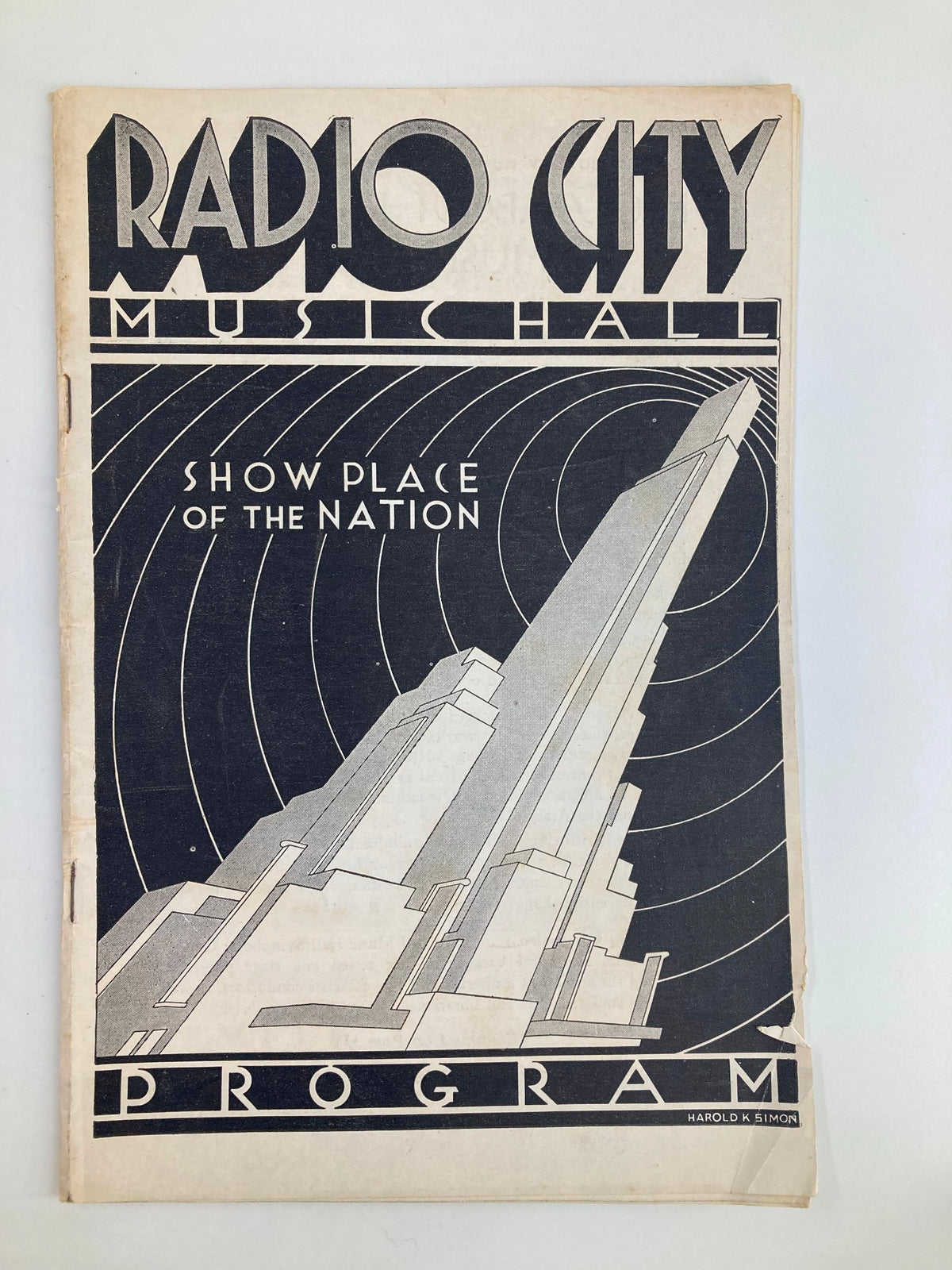 1935 Radio City Music Hall Show Place of the Nation program cover featuring art deco design, with bold typography and a graphic representation of the building.