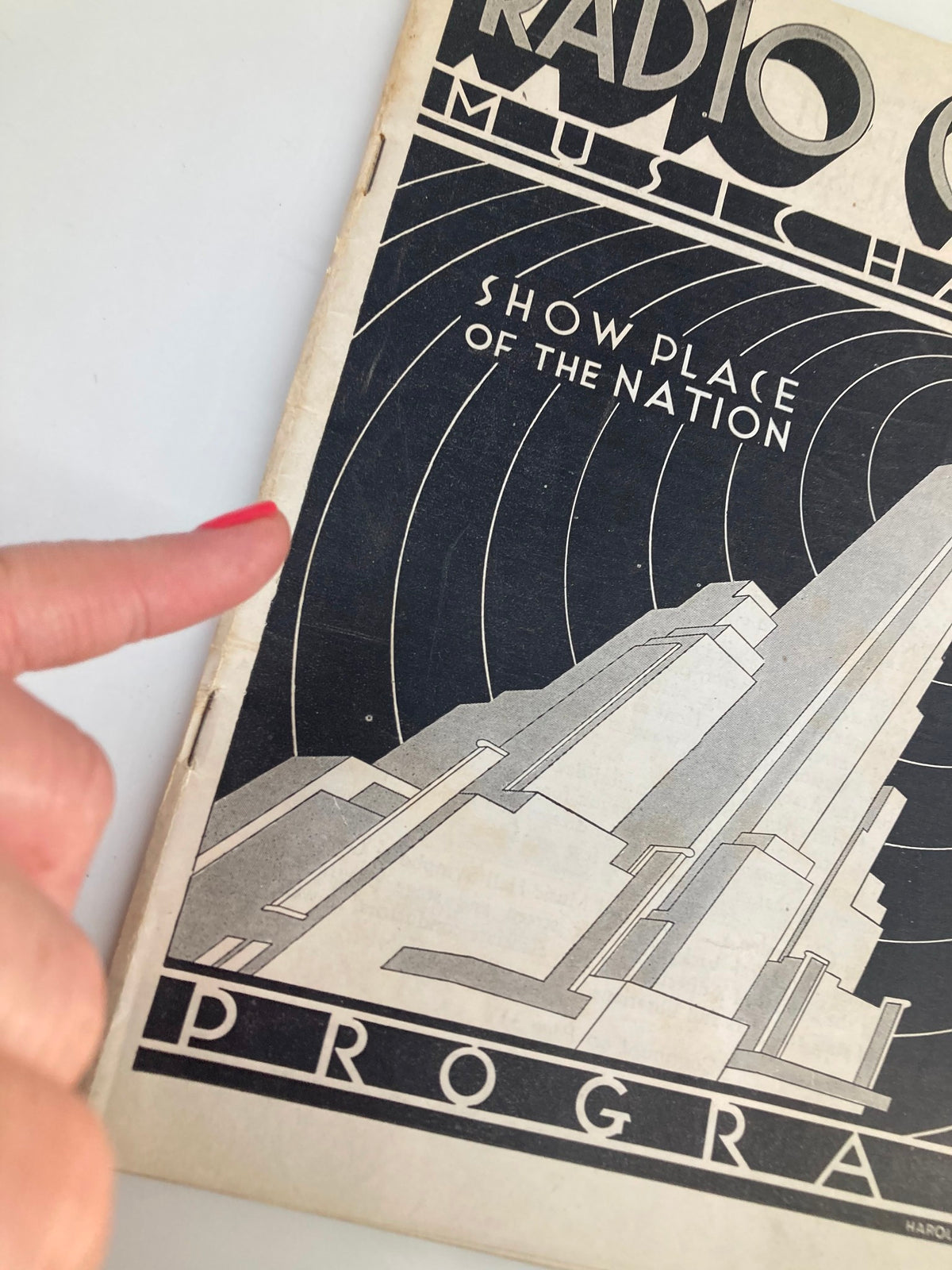 Cover of the 1935 Radio City Music Hall Show Place of the Nation program, featuring art deco design and a skyscraper illustration.