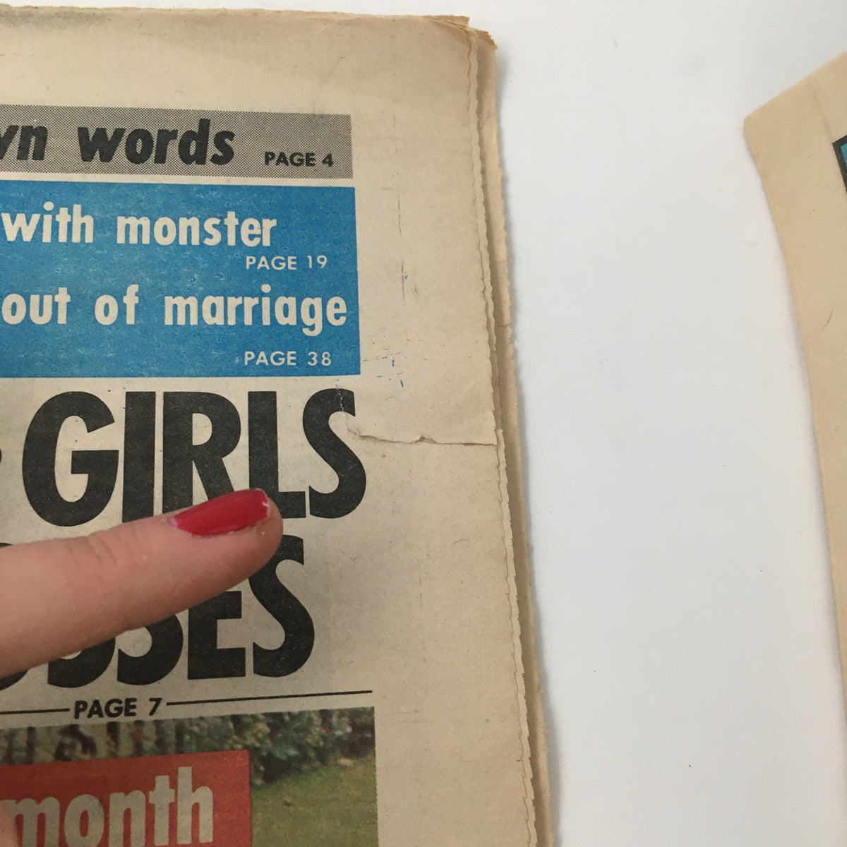 Close-up of The Star Newspaper from May 18, 1976, showing a highlighted headline 'GIRLS SUE TOP GOVT. BOSSES' and the edge of the newspaper, which indicates some wear and tear.