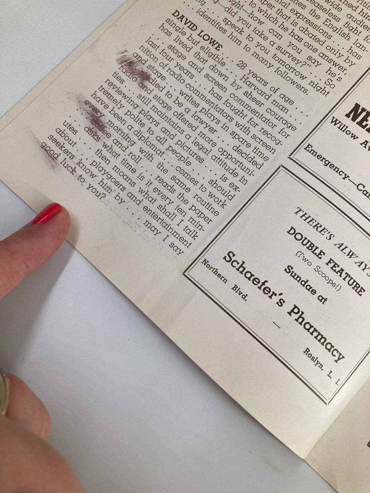 Close-up view of a vintage 1940 playbill for "Our Town" by Thornton Wilder. The image shows partially faded text with a fingertip pointing at an article, highlighting the historical details and wear characteristic of its age.