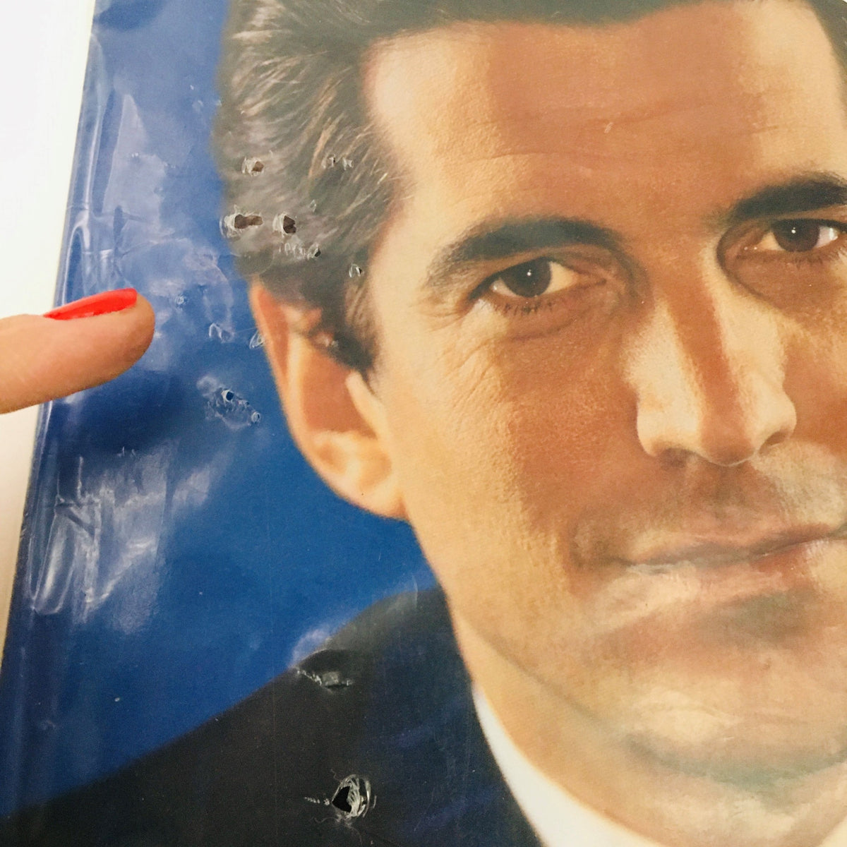 Close-up of the cover of George Magazine May 2001 Farewell Issue featuring John Kennedy with minor imperfections on the plastic seal, highlighting its collectible quality.