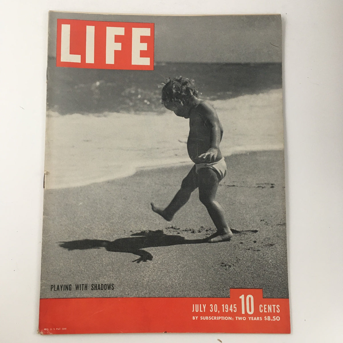 Life Magazine July 30 1945 Photograph of a Baby Playing with Shadows, showcasing a vintage cover with a playful infant interacting with its shadow at the beach.