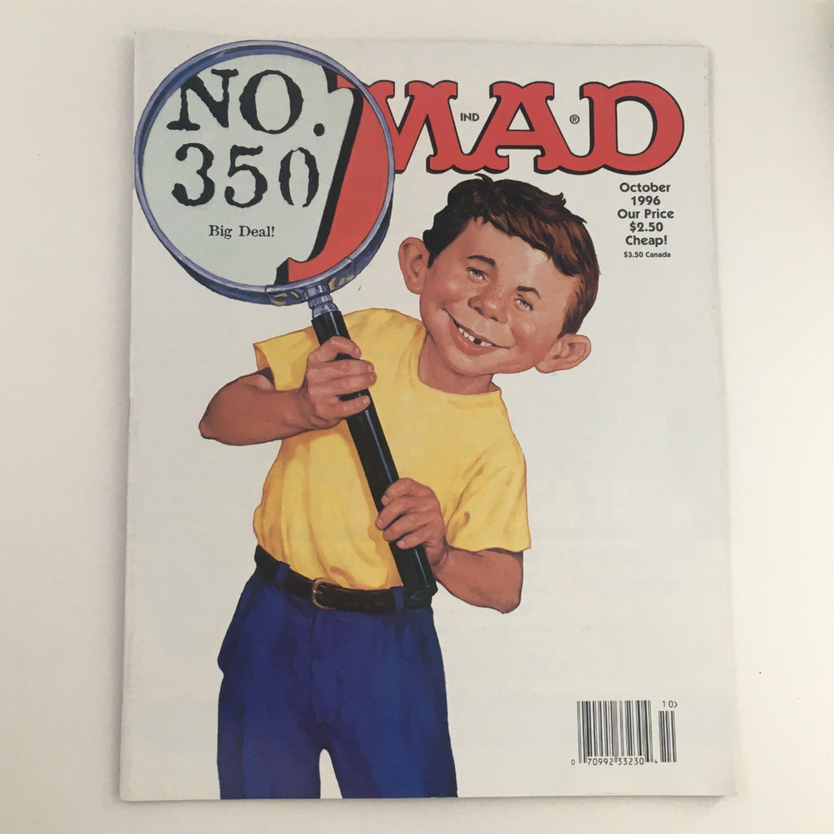 Cover of Mad Magazine October 1996 No. 350 featuring Neuman and a magnifying glass. The image showcases a cheerful character holding the magnifying glass with the issue number prominently displayed.