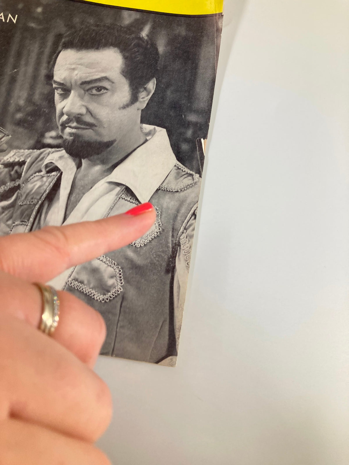 Close-up view of the 1962 Playbill for The Broadway Theatre, highlighting Alfred Drake in character from Kean, with a finger pointing to an area of interest.