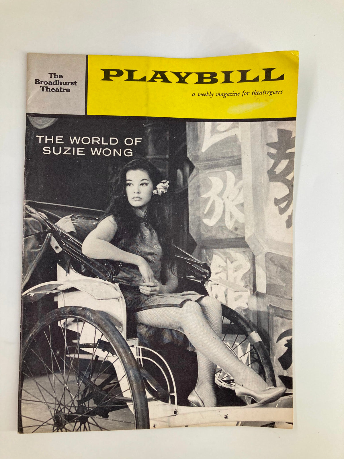 1959 Playbill The World of Suzie Wong by Paul Osborn featuring a cover image of a woman seated with traditional Hong Kong elements in the background.