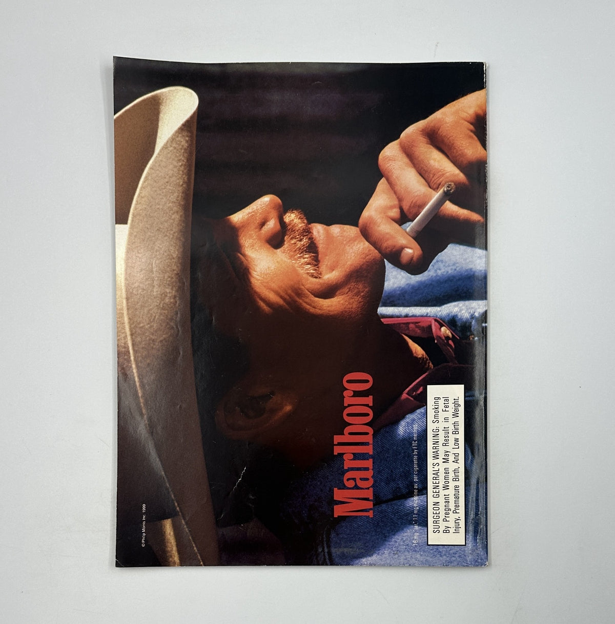 Vintage Marlboro advertisement showcasing a rugged cowboy enjoying a cigarette, emphasizing the brand's iconic imagery and lifestyle association.