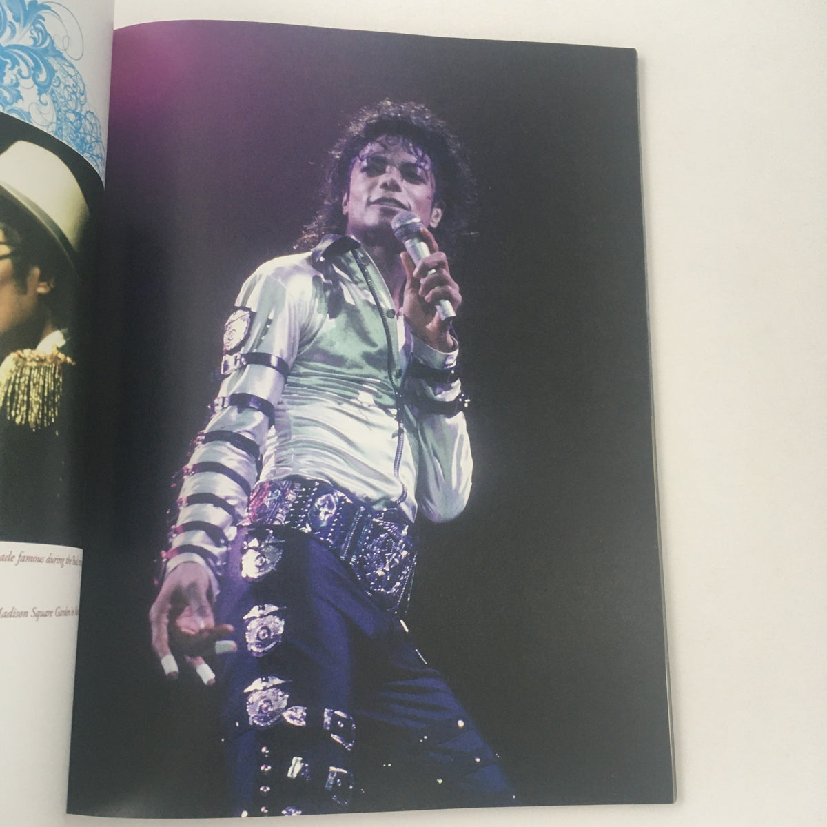 A Tribute To An American Icon: Michael Jackson The One and Only interior page showcasing Michael Jackson performing on stage, dressed in a shiny jacket and holding a microphone, embodying the essence of his legendary performances.