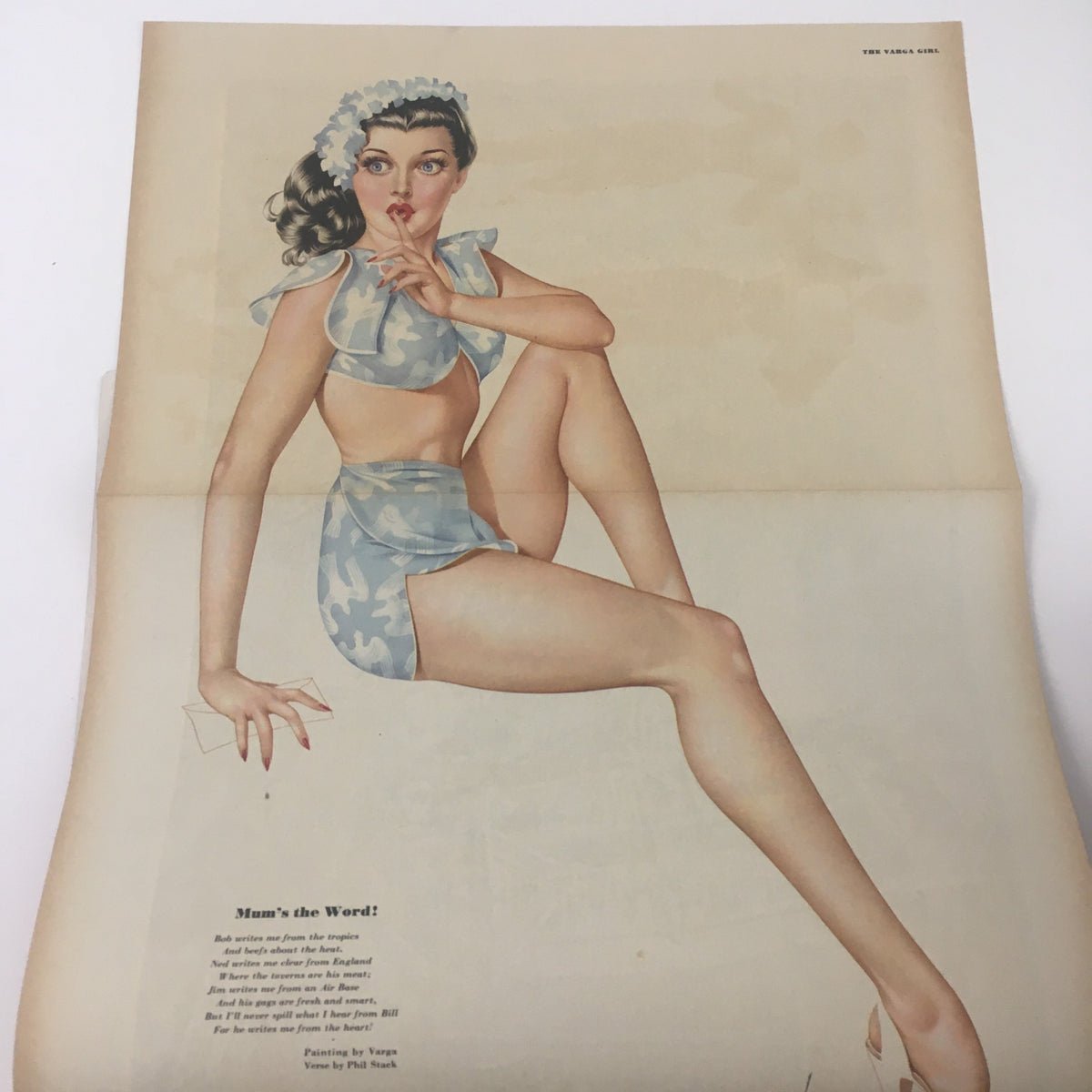 Vintage artwork from Esquire Magazine October 1945 featuring a pin-up girl illustration by Vargas. The image showcases a woman in a light blue bikini, striking a playful pose, highlighting the fashion and style of the 1940s era.