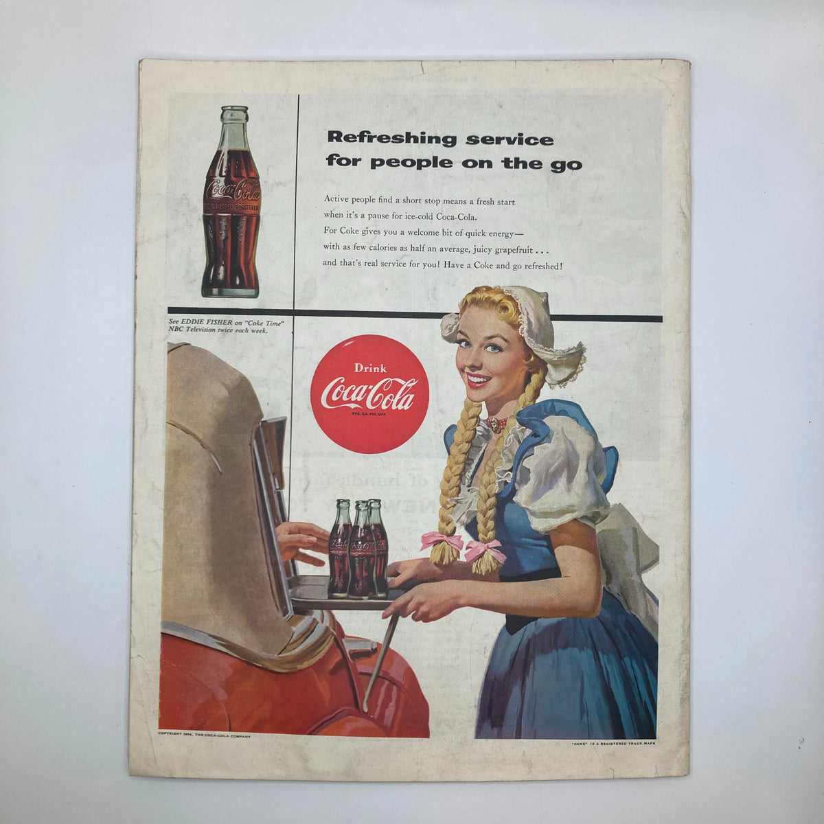 Vintage Coca-Cola advertisement from the Saturday Evening Post Magazine dated October 2, 1954, featuring a cheerful woman in a folk costume serving ice-cold Coca-Cola, highlighting the refreshing service for active people.