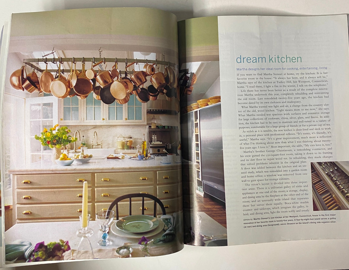 A beautifully designed kitchen from Martha Stewart Living Magazine September 1996 showcasing copper pots hanging from a rack, a light-filled space with a dining table adorned with flowers and elegant dinnerware.