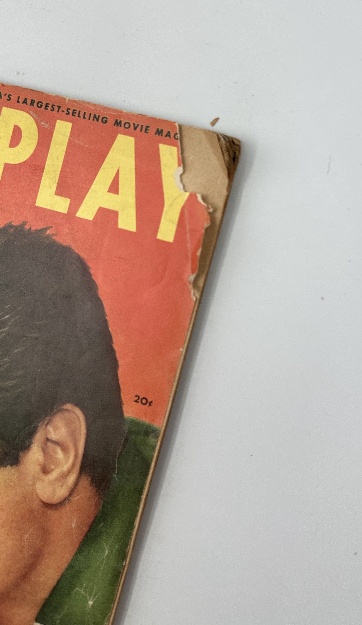 Close-up of the corner of Photoplay Magazine October 1954, depicting wear on the cover with the title prominently displayed.