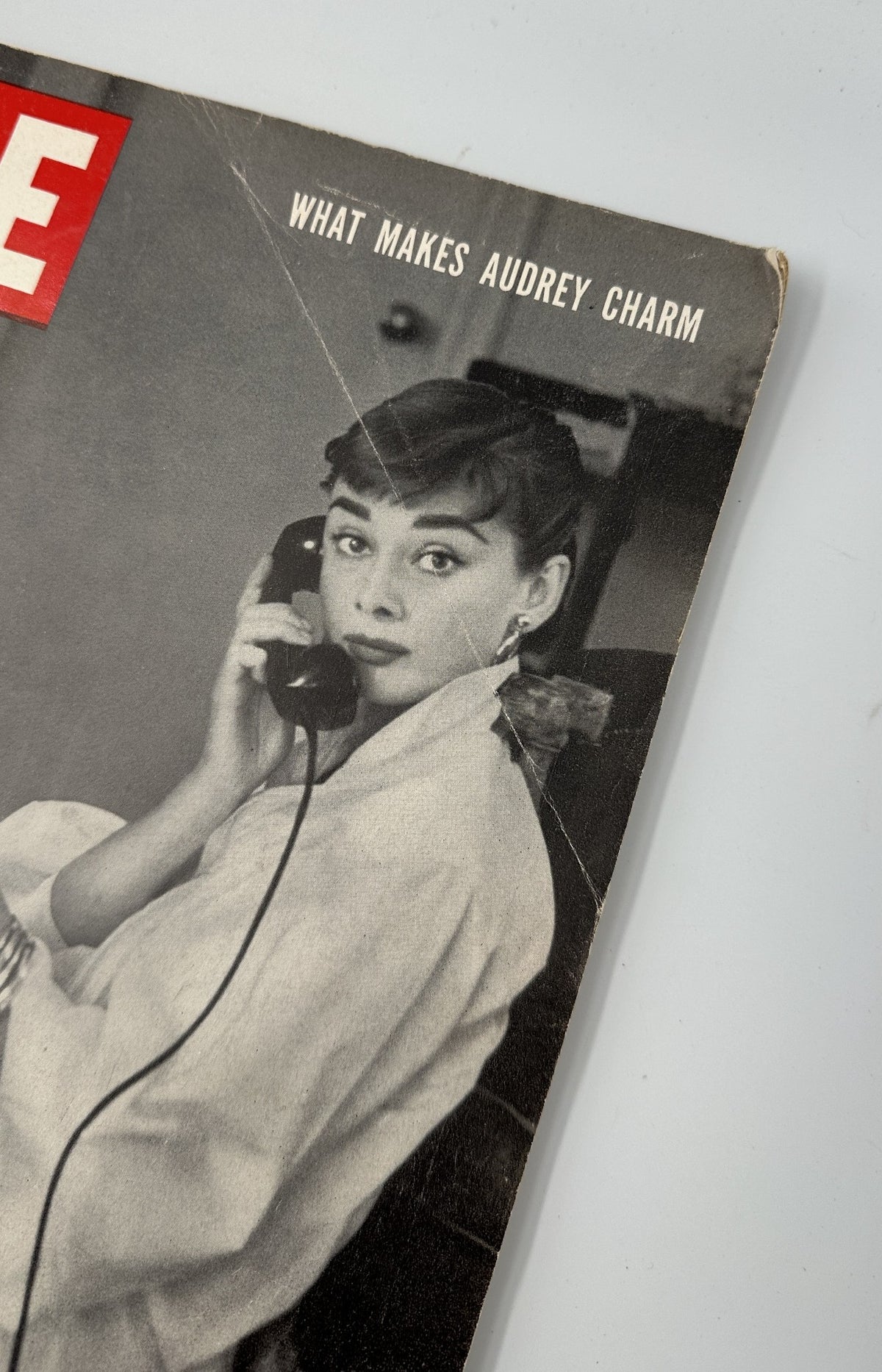 Close-up of Life Magazine December 7, 1953 cover with Audrey Hepburn, titled 'What Makes Audrey Charm,' highlighting her captivating look.