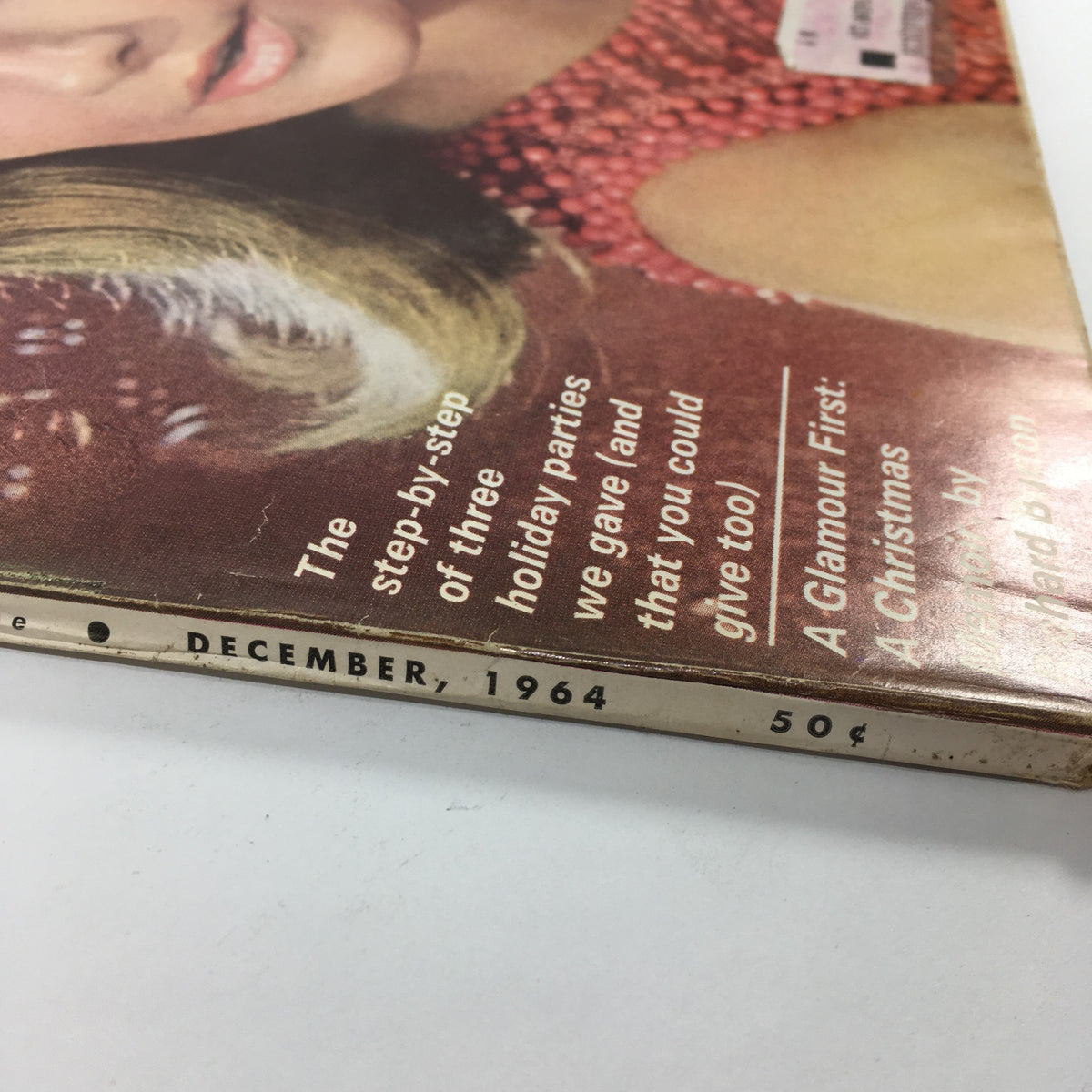 Spine of VTG Glamour Magazine: December 1964 - Holiday Beauty Issue displaying the publication date and price, highlighting its vintage charm.