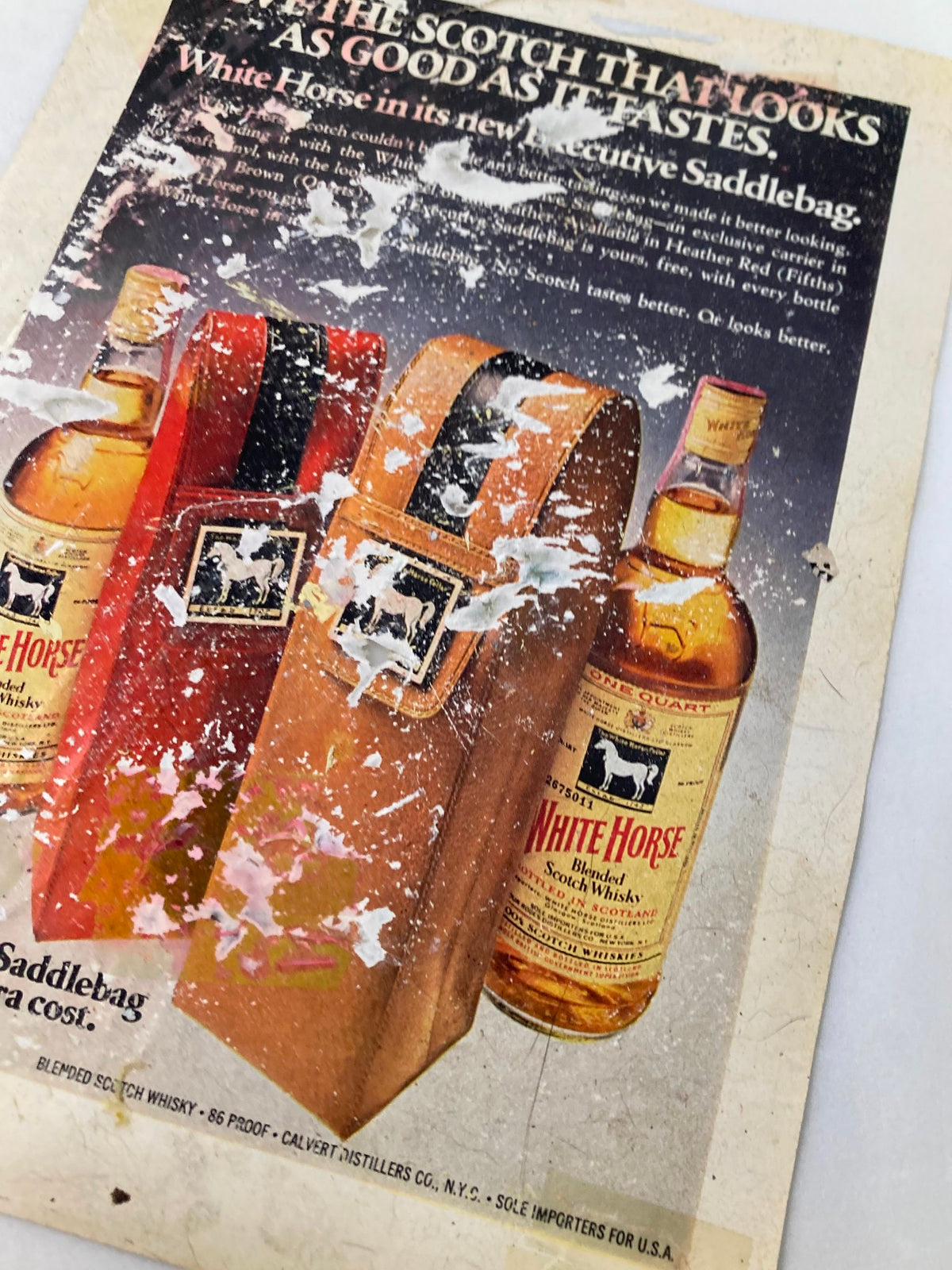 Vintage advertisement for White Horse Blended Scotch Whisky featuring two bottles and associated packaging, highlighting the slogan 'The Scotch That Looks As Good As It Tastes'.