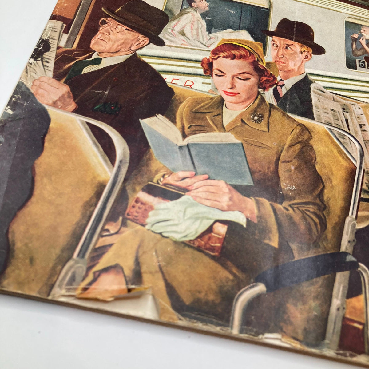 Close-up view of the cover art from the Saturday Evening Post Magazine, September 24, 1955, featuring 'The Commuters' by George Hughes, focusing on a woman reading a book among other passengers.