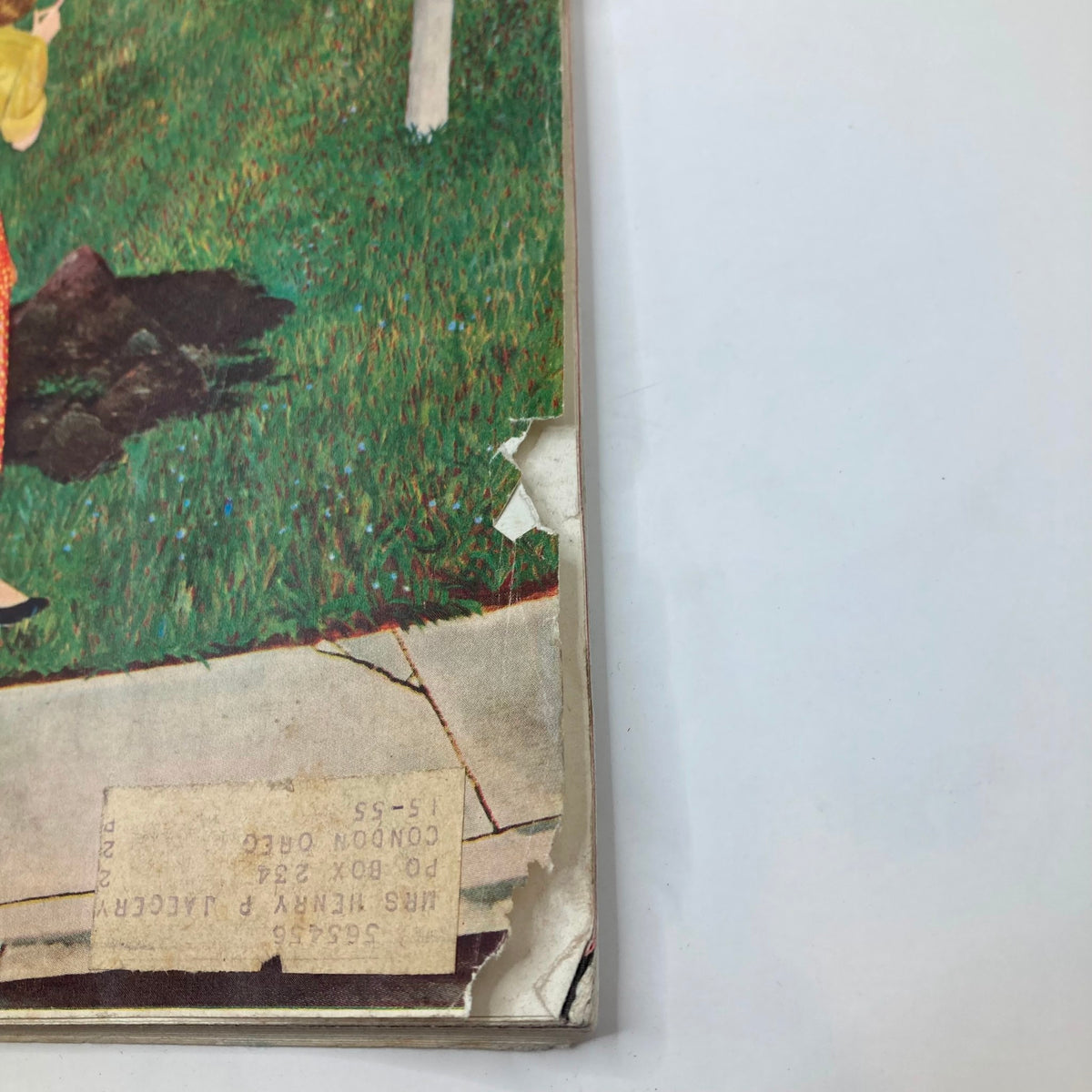 Close-up view of the edge of the Saturday Evening Post Magazine dated April 9, 1955, showing some wear and tear along with a label.