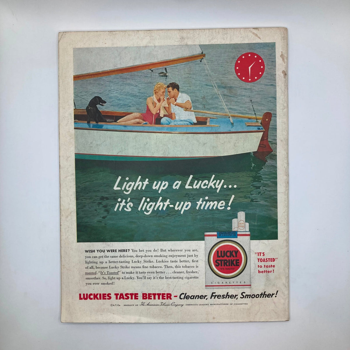Vintage advertisement from the Saturday Evening Post Magazine June 25 1955 featuring a couple on a boat with their dog, promoting Lucky Strike cigarettes with the slogan 'Light up a Lucky... it's light-up time!'.