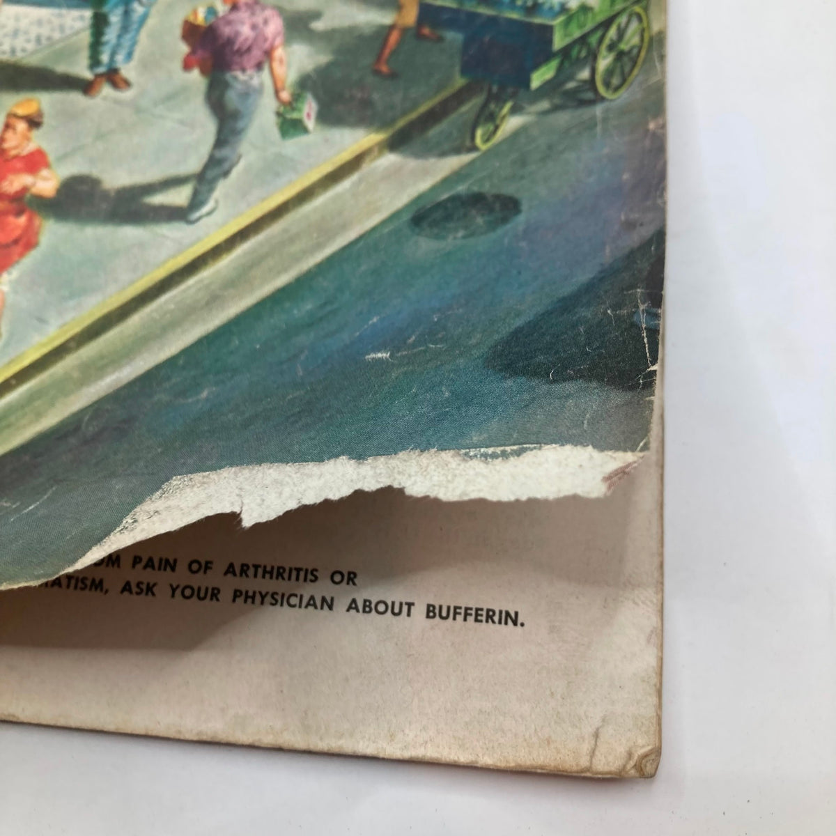 Close-up of the edge of the cover of the Saturday Evening Post magazine from June 18, 1955, showing wear and tear with visible damage along the bottom edge.
