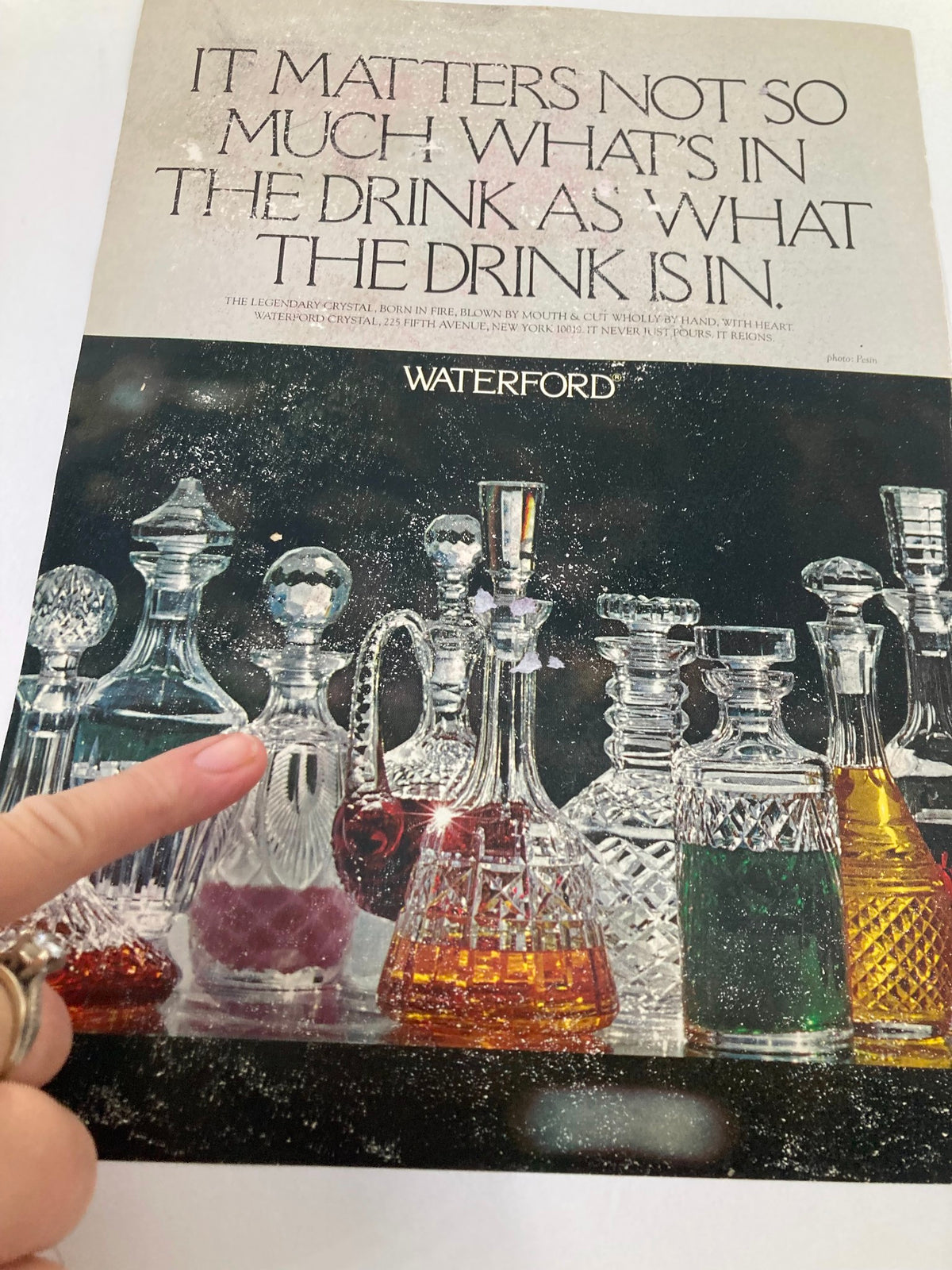 Advertisement featuring Waterford crystal decanters with a quote about drinks, showcasing elegant glassware and design, perfect for luxury home decor.