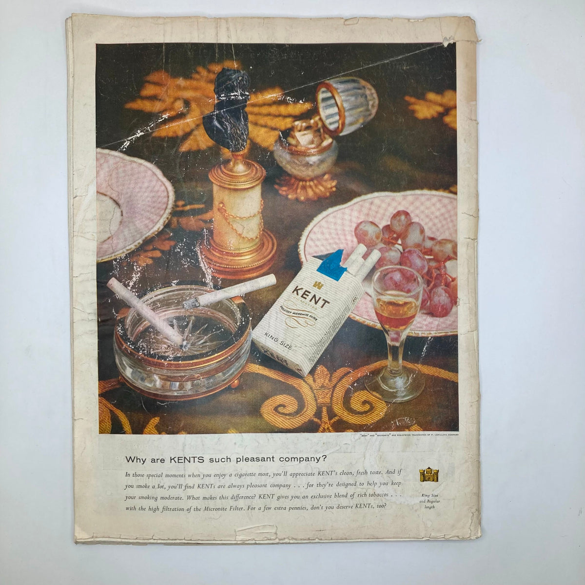 Advertisement from Saturday Evening Post Magazine February 11 1956 for Kent cigarettes, showcasing a still life setting with cigarettes and decorative items.
