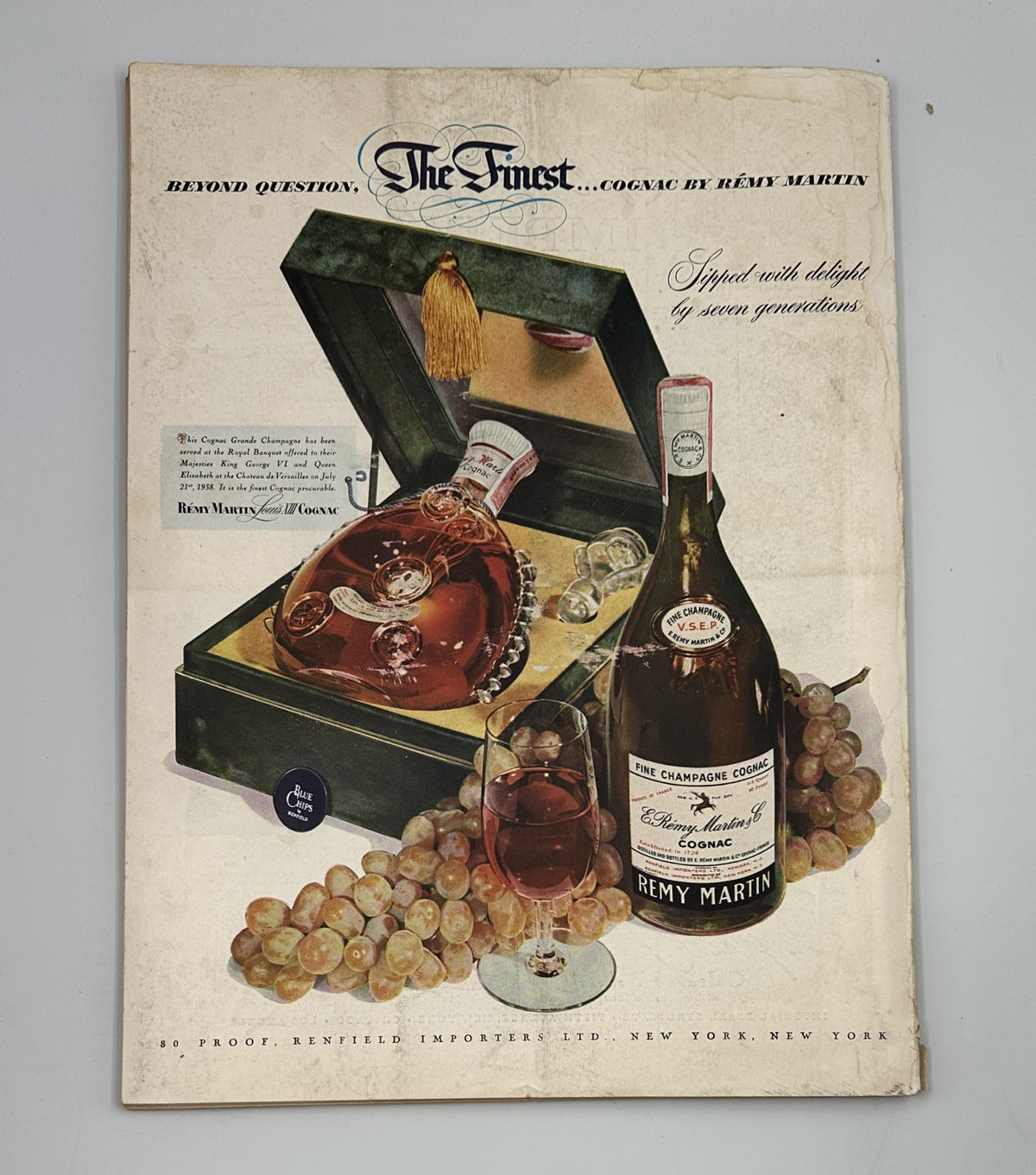 Flair Magazine December 1950 Christmas Issue featuring an advertisement for Rémy Martin cognac, showcasing a luxurious bottle and elegant presentation with grapes.