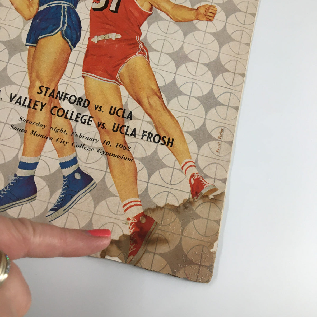 Close-up of the February 10, 1962 NCAA Basketball Stanford vs UCLA Official Program showing edge wear and damage, highlighting its vintage character.