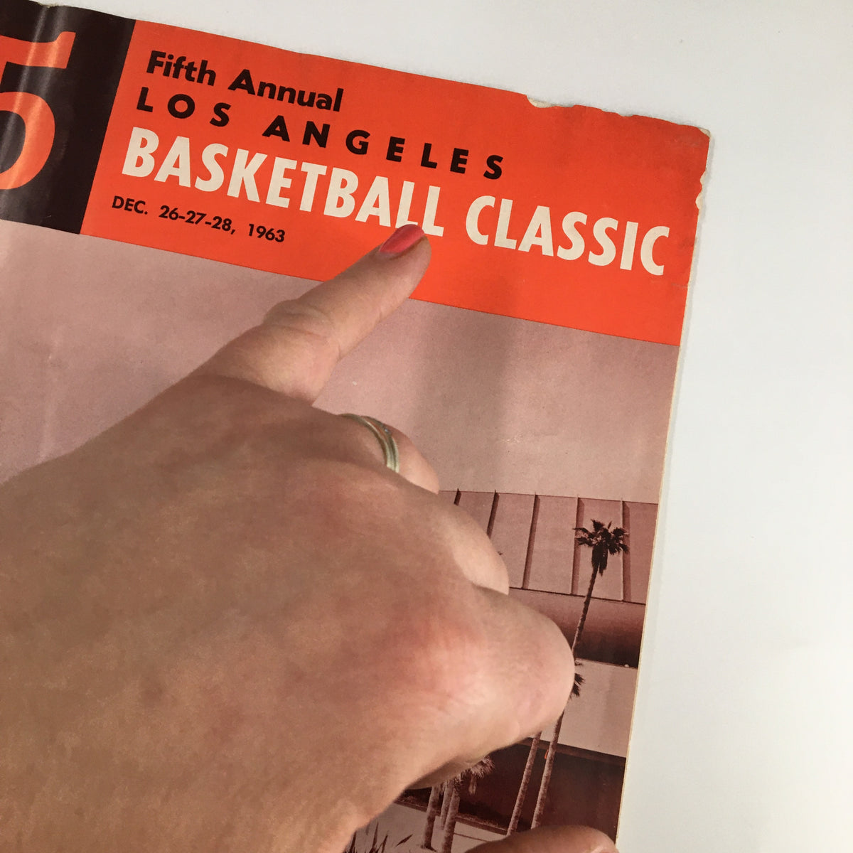 Cover of December 26, 1963 NCAA USC vs UCLA Basketball Classic Official Program featuring bold text and a hand pointing to the title.