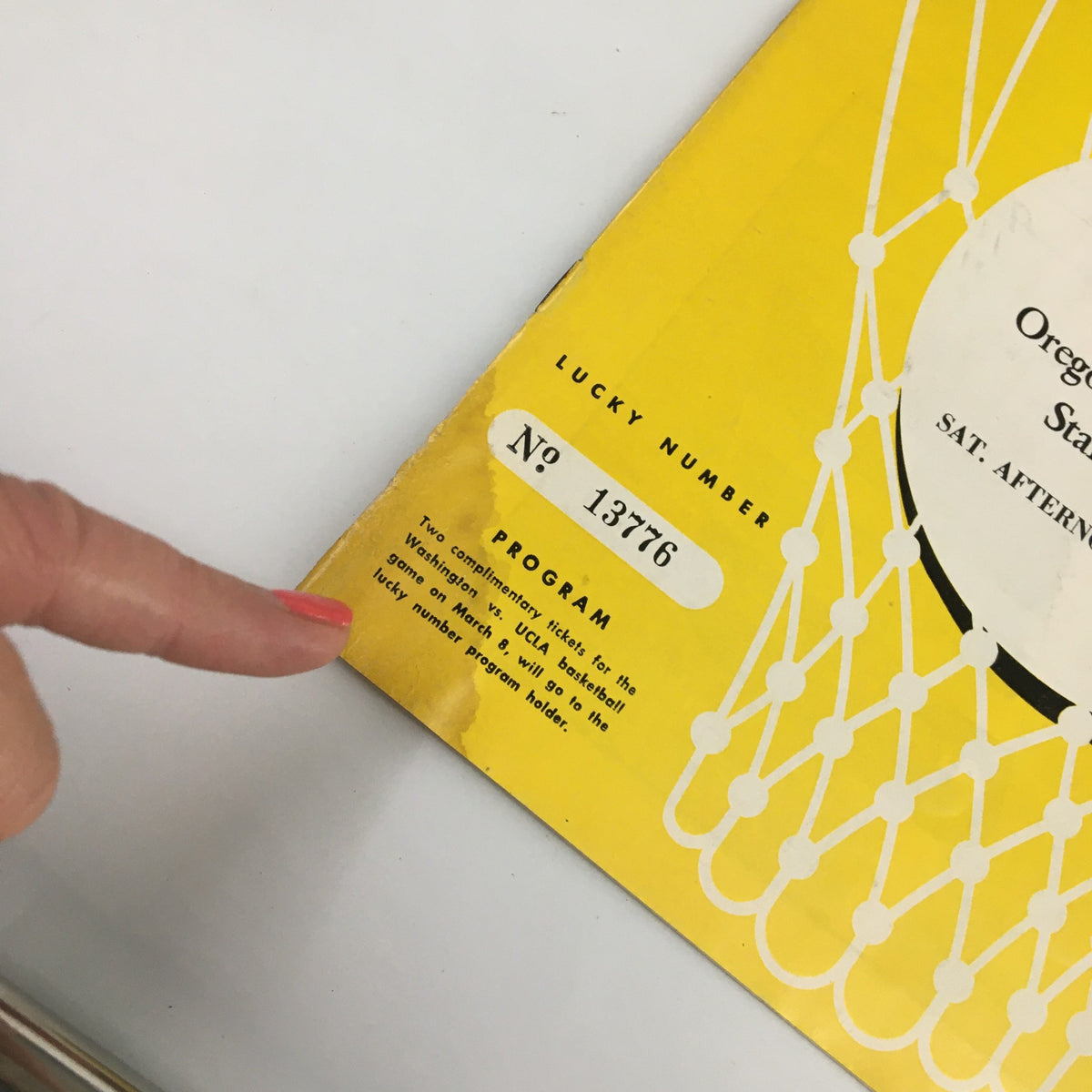 Detailed view of the February 22, 1958 NCAA Basketball Official Program, showing the lucky number and condition with visible wear, emphasizing its collectible value for sports enthusiasts.