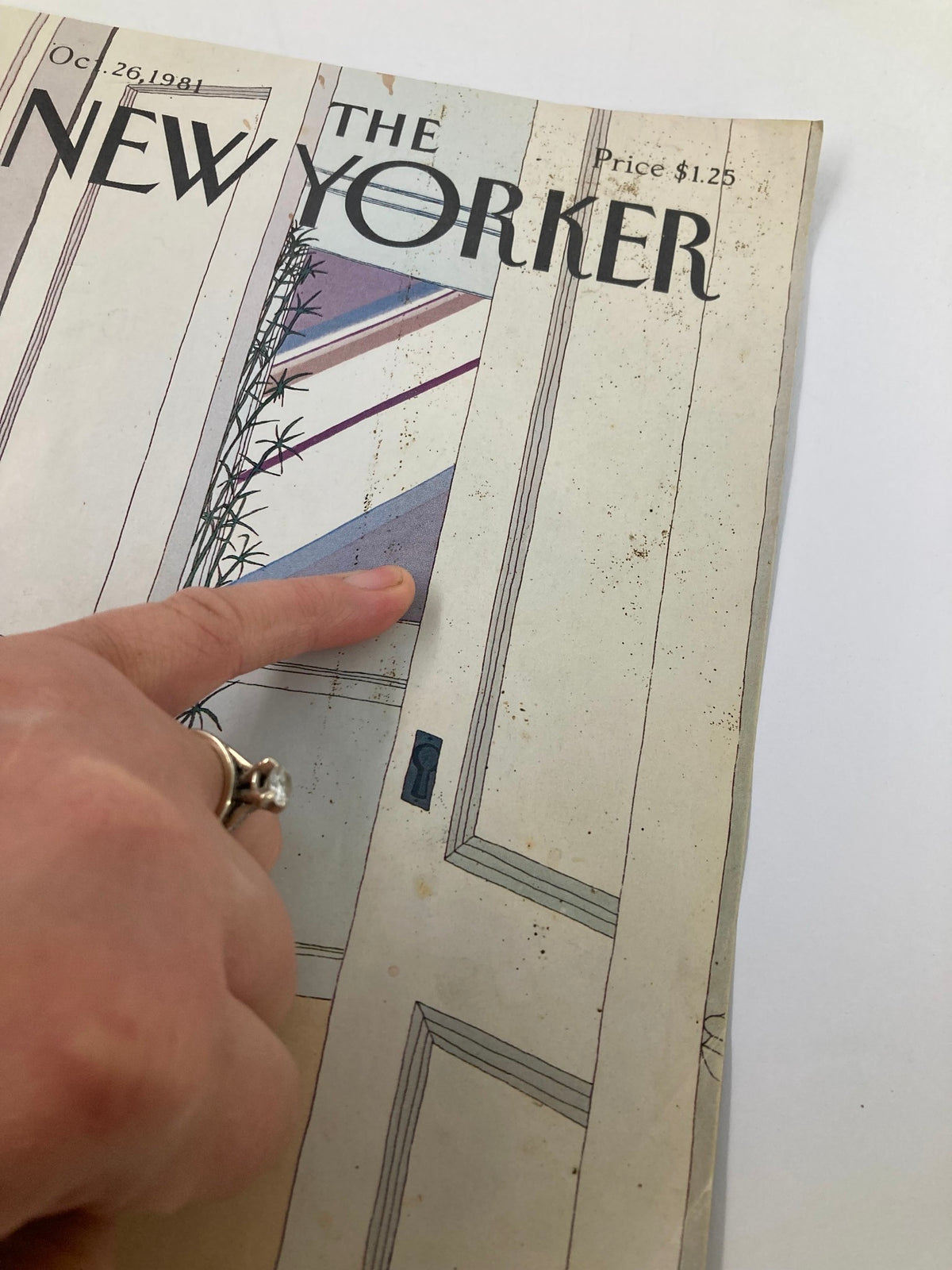 Close-up view of the cover of The New Yorker October 26 1981 Open Doors by Gretchen S. with a finger pointing at the illustration and visible wear on the cover.