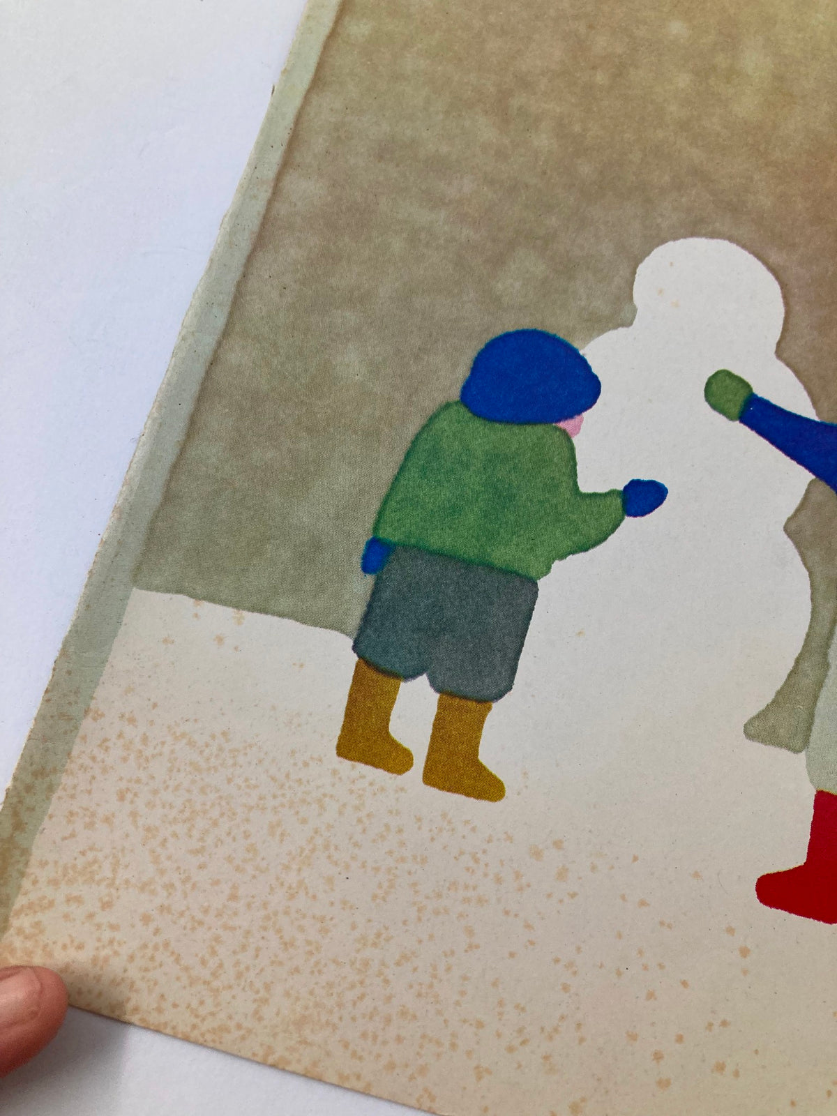Close-up of a vintage New Yorker magazine cover from January 24, 1983, featuring a colorful winter scene with a blue-hatted child in green and yellow boots, depicted beside a snowman, designed by Heidi Goennel.