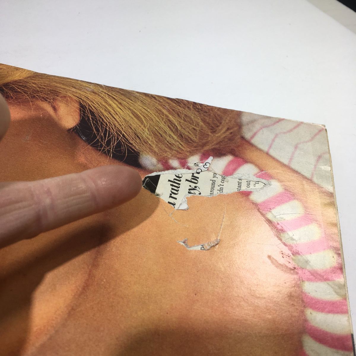Close-up of the cover damage on VTG Glamour Magazine: June 1973, showcasing a torn area near the binding, indicative of its vintage condition.