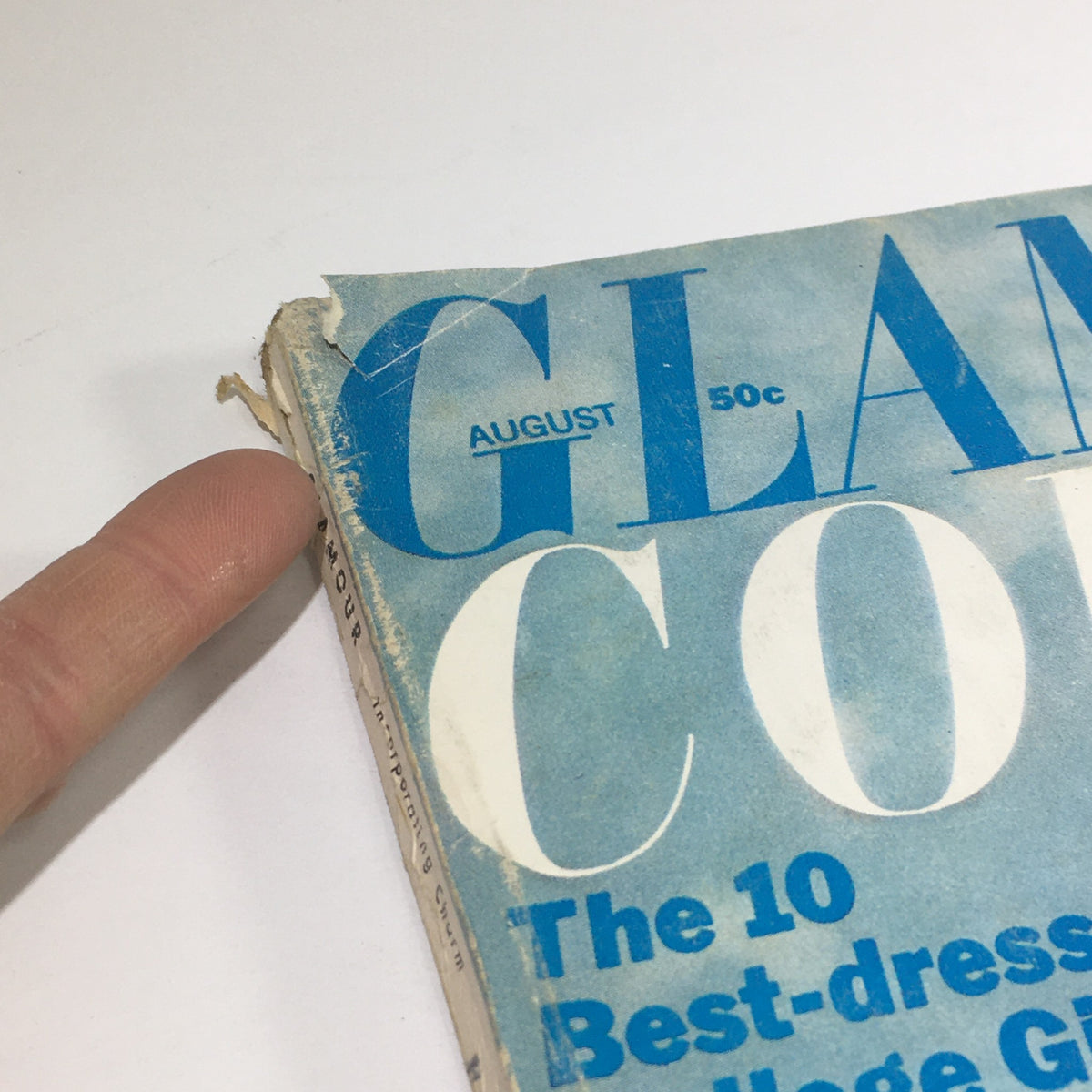 Close-up of the top corner of the VTG Glamour College Magazine: August 1966, showing minor wear and tear. The title emphasizes 'Glamour' and indicates the contents, including fashion tips and college highlights, reflecting the vintage aesthetic.