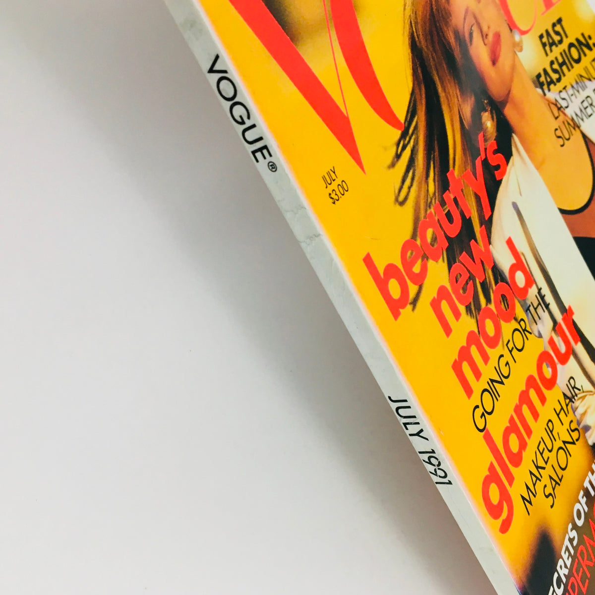 Close-up of Vogue Magazine July 1991 spine displaying the title and publication date, emphasizing its vintage appeal. The side view captures the magazine's excellent condition and iconic design featuring Karen Mulder.