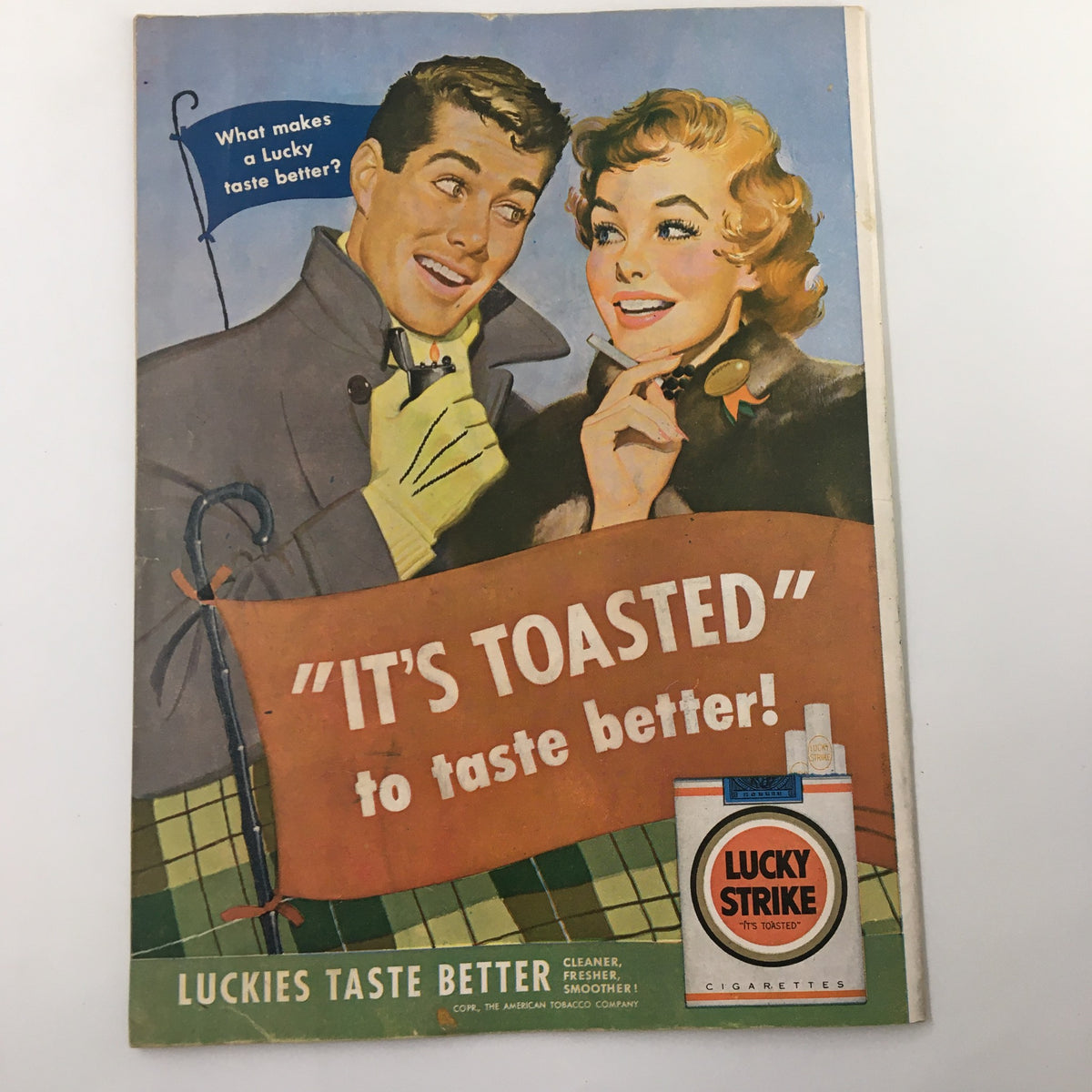 Vintage advertisement for Lucky Strike cigarettes with a slogan 'It's Toasted' featuring a smiling couple.