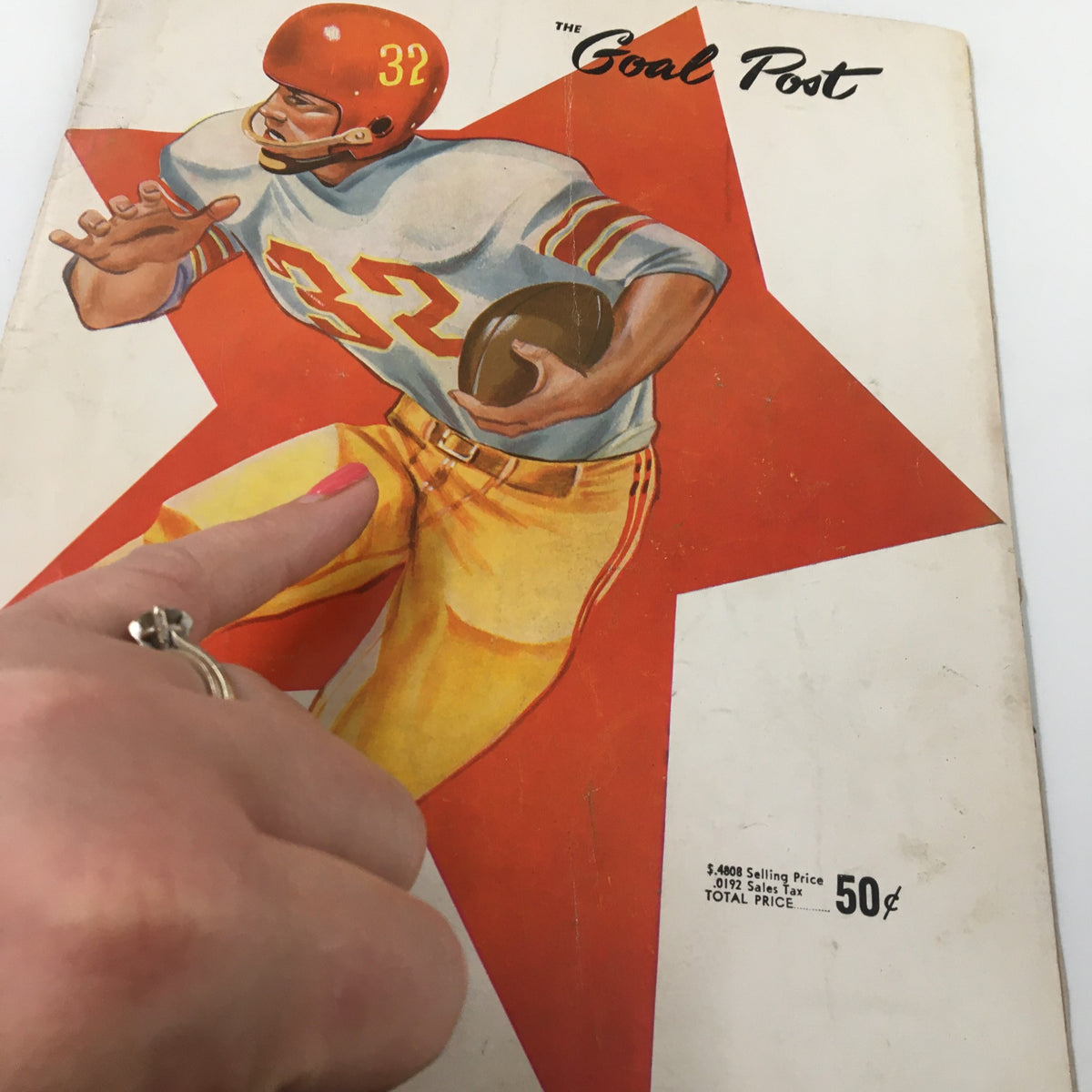 Close-up of the cover of 'The Goal Post' booklet, displaying a football player and the title, celebrating the November 19, 1960 NCAA Football game between USC Trojans and UCLA Bruins.