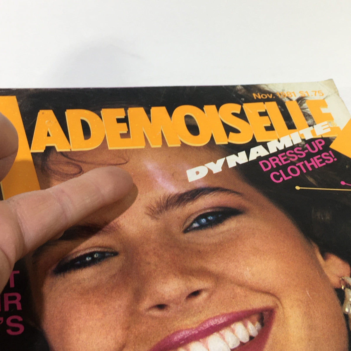 Cover of VTG Mademoiselle Magazine: November 1981 featuring vibrant typography and a close-up of a smiling model with beautiful blue eyes. Highlighted text includes 'DYNAMITE DRESS-UP CLOTHES!' emphasizing fashion content.
