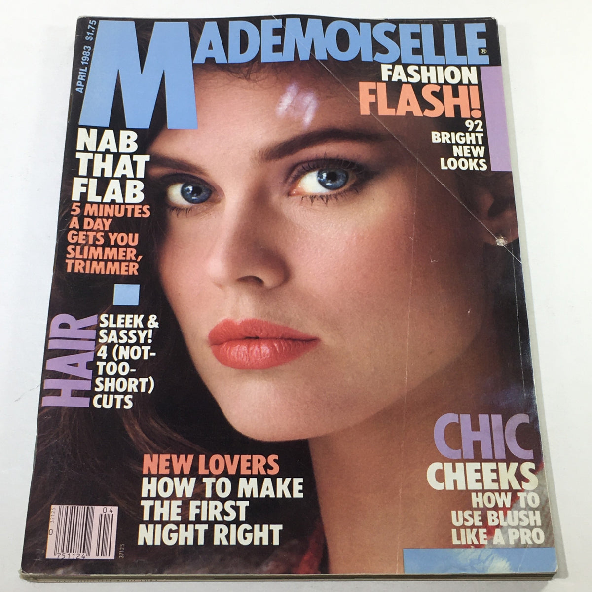 VTG Mademoiselle Magazine from April 1983 featuring a stunning cover by Jenny Howorth, showcasing a model with blue eyes and vibrant makeup, highlighting 80s fashion trends.